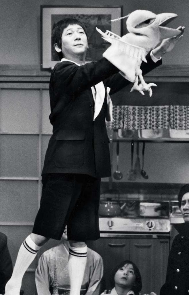 1970年代に絶大な人気を博した番組「みごろ！たべごろ！笑いごろ!!」（テレビ朝日系）で「しらけ鳥音頭」を歌う小松政夫さん。この番組では、小松さん扮する「小松与太八左衛門」と伊東四朗さん扮する「ベンジャミン伊東」が踊る「電線音頭」も大流行。（写真／朝日新聞社）