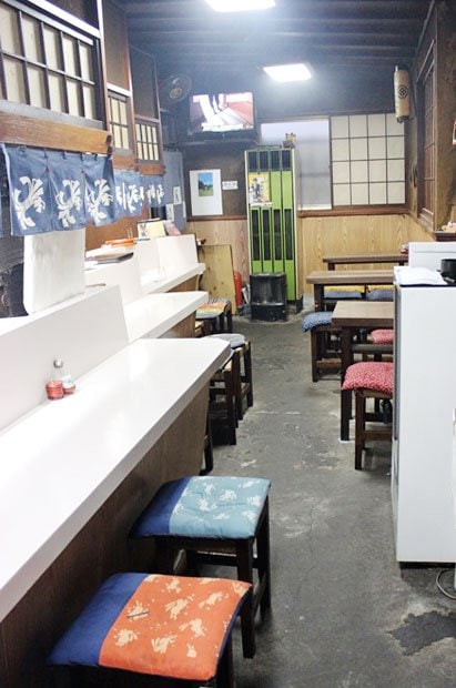 【よしだ】店内。長いカウンターとテーブル。団体用の座敷もある