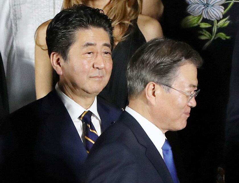 すれ違いの溝が埋まらない安倍晋三首相（左）と文在寅大統領 （c）朝日新聞社