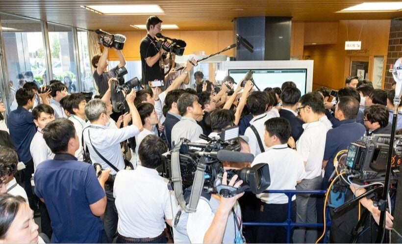 総会が行われた党本部入り口には多数の報道陣が詰めかけた
