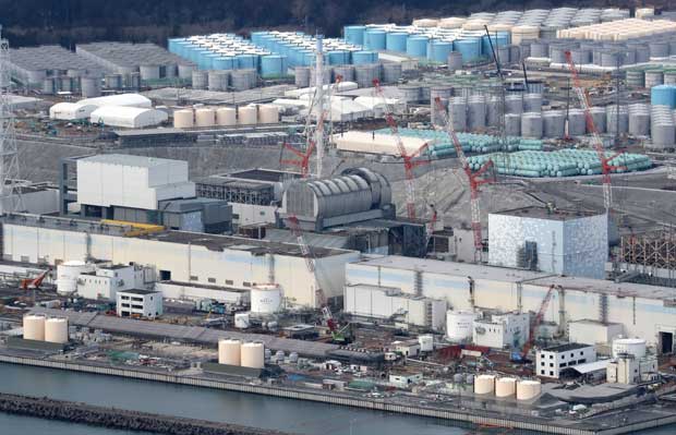 福島第一原発（２０１８年２月２１日）。手前右から２号機、３号機、４号機の建屋。３号機は、カマボコ形のドームが完成した。背後には汚染水をためるタンクが立ち並ぶ　（ｃ）朝日新聞社