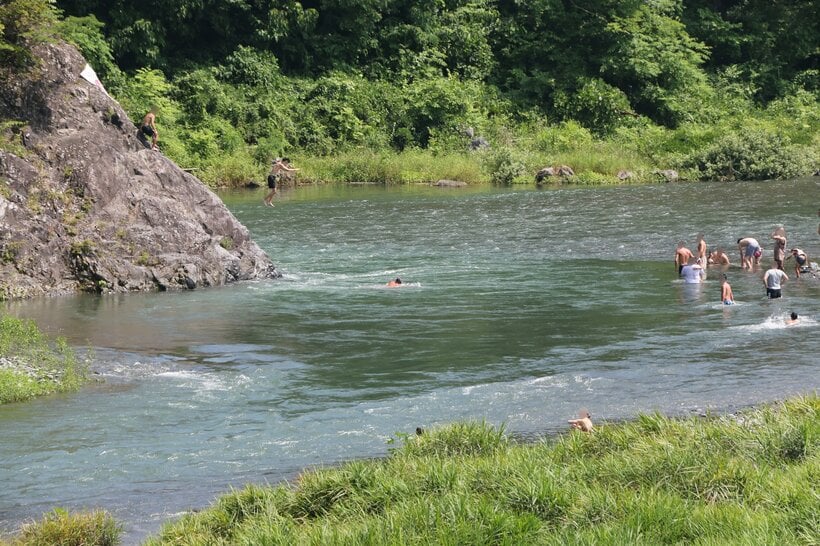 岩の上から川に飛び込む人。東京都青梅市の多摩川で＝米倉昭仁撮影