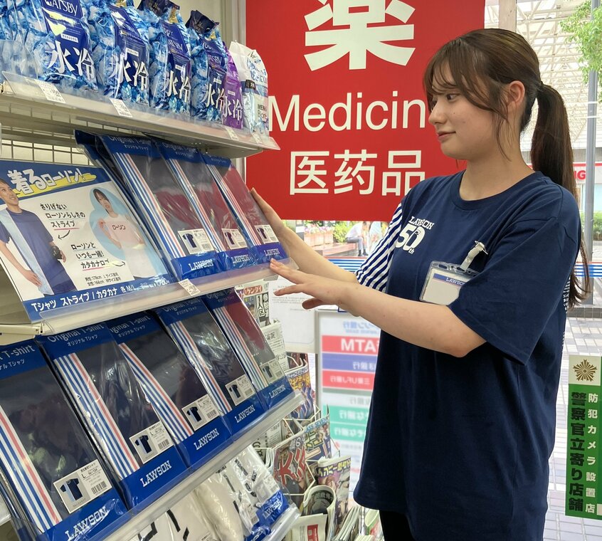 50周年記念Tシャツを着用した店舗従業員。陳列棚に並んでいるのが販売しているTシャツ