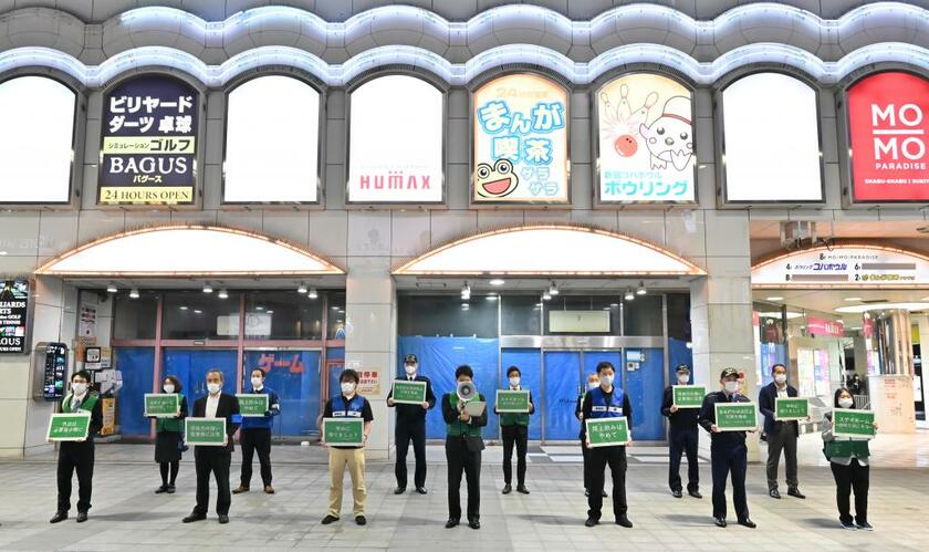 感染拡大を防止するため、歌舞伎町を訪れている人たちに外出自粛を呼びかける、東京都の職員ら。４月２３日撮影（ｃ）朝日新聞社