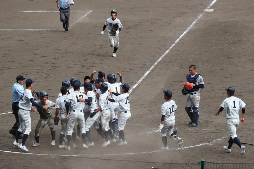 九回裏2死一、二塁、新沢の逆点サヨナラ三塁打で試合を決め、喜ぶ明徳義塾の選手たち（撮影／写真部・松永卓也）