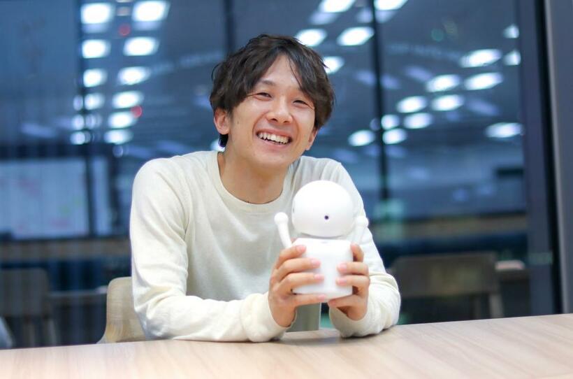 ミニドラを目指して作製中のロボットを手にする大澤正彦さん。大学の講義は週８コマ。論文執筆、企業との共同研究に講演もこなす（写真：大澤さん提供）