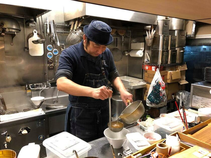 ラーメンをふるまう飯野さん（筆者撮影）