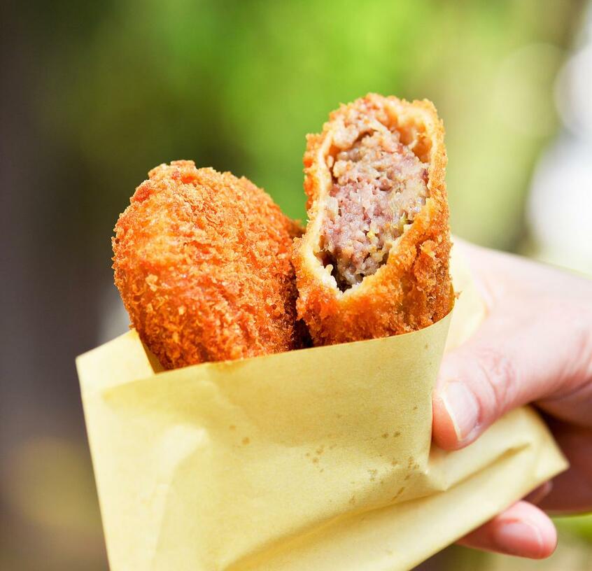 祖師谷鈴木 メンチとコロッケ/商店街で地元の人々に長く愛される精肉店。名物のメンチやコロッケは、店で扱うA5ランクの黒毛和牛の端肉を贅沢に使う。メンチ(写真)は甘みのある肉と玉ネギがぎっしり詰まってボリューム満点(160円)。コロッケはジャガイモと肉のほろっとしたやさしい味わい(105円)。豚のヒレカツや鶏の唐揚げも人気。午前中で売り切れることも多いので早めに出かけたい。税別 (撮影/掛祥葉子)
