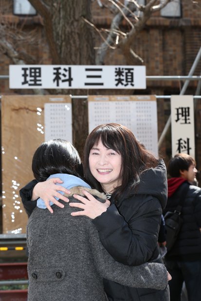 合格発表の掲示板の前で抱き合う佐藤ママと長女（撮影／写真部・加藤夏子）