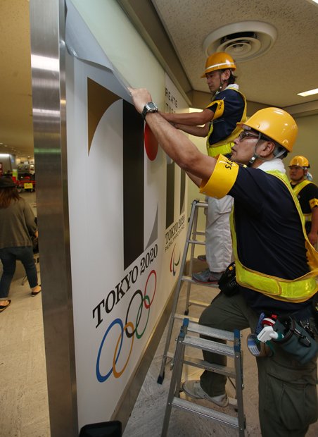 ２０２０年東京五輪・パラリンピックのエンブレムをはがす作業員（ｃ）朝日新聞社