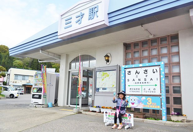 ３歳児の記念撮影スポットとして人気を集めているしなの鉄道の三才駅。写真ではエプロンはしていないが、女の子用の駅長帽子をかぶりご満悦だ