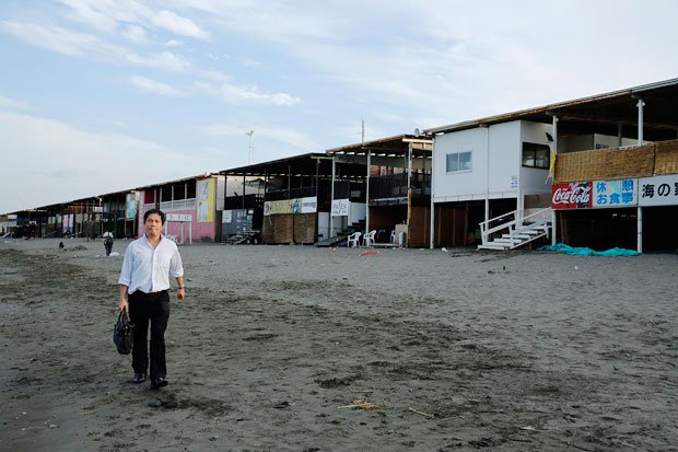 AM６：２８起業は韮澤さんにとって１０年来の夢。早朝の人けのない海岸で構想を練る。海の家経営で得た利益は、起業家の事業に投資する計画だ（撮影／今村拓馬）