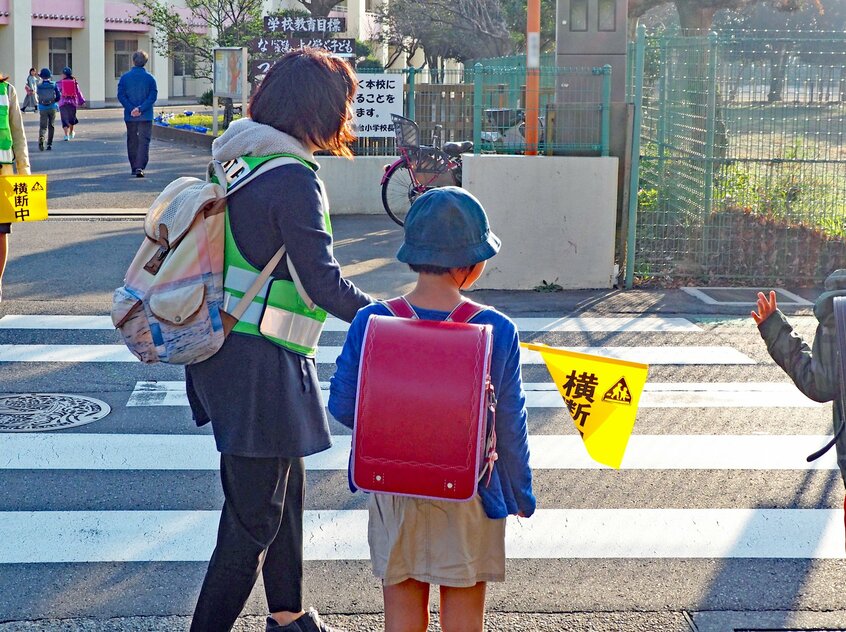 子どもたちを学校前の横断歩道で保護者が見守る「旗当番」もPTAが当番表を作成して運営する(写真:米倉昭仁)