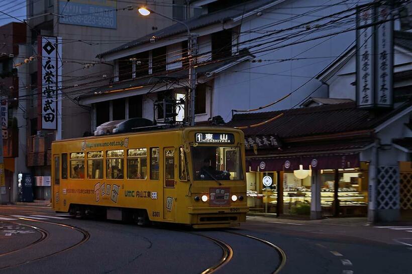 中納言停留所を発車して、ゆっくりと東山に向かう岡山電気軌道の路面電車。背景の吉備団子店舗のイメージを損なわないように軽いタッチでズーム流し撮りした。キヤノンEOS 5DII EF24－105mmF4L IS（65m→58mm） 1／50秒 f5.6 ISO800（撮影／諸河久：2011年11月6日）