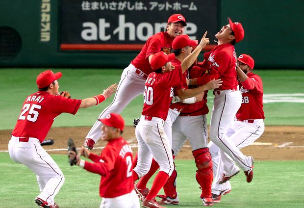25年ぶりの優勝を決め、抱き合って喜ぶ広島の選手たち=10日、東京ドーム、上田潤撮影 (c)朝日新聞社