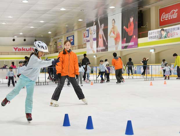 大須スケートリンクのジュニアスクールで練習する子どもたち。このリンクから世界に羽ばたいた４人の選手のバナーが掲げられている（写真：大須スケートリンク提供）