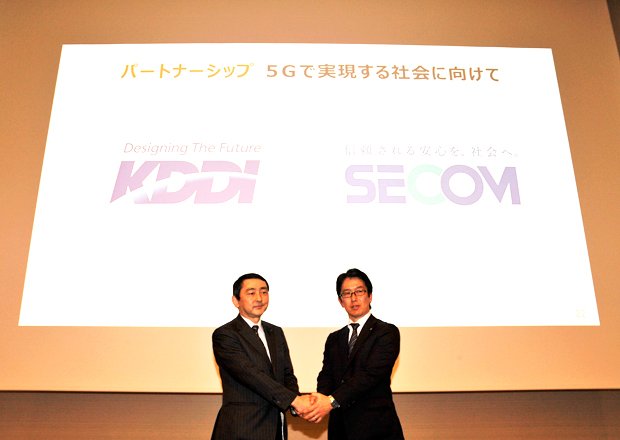 「5G」実現に向け握手を交わす、KDDI技術開発本部の松永彰・シニアディレクター（左）とセコム企画部の寺本浩之・担当部長