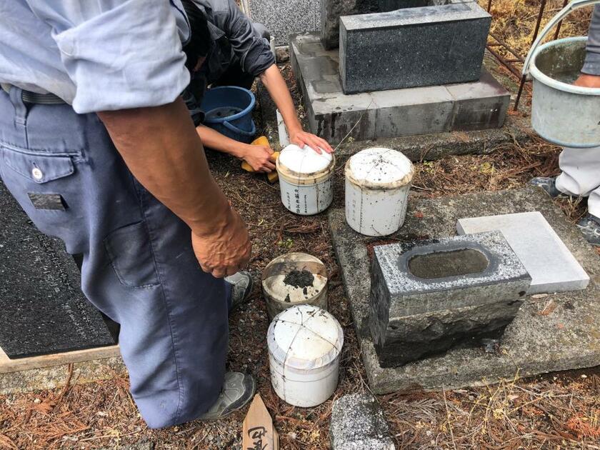 改葬作業の状況。墓から取り出された骨壺は丁寧に扱われる＝サンテレーヴ提供