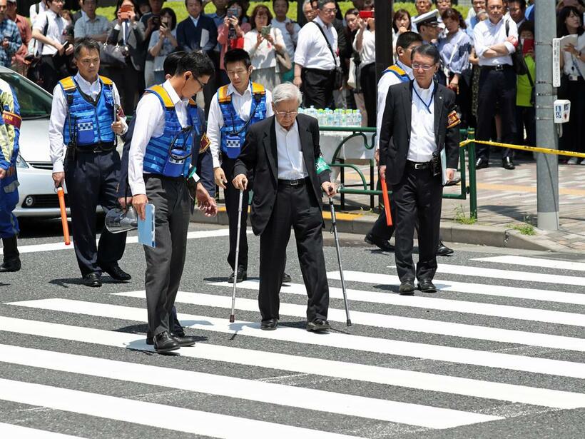 2019年6月池袋の事故現場で実況見分に杖をつきながら立ち会う飯塚被告（C)朝日新聞社