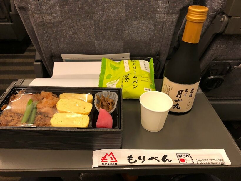 私の「#居酒屋新幹線」。お品書きは、山形産のハーブ鶏をつかったそぼろとモモ肉、だしまき玉子のお弁当。ずんだを使った生クリームパン。そして大吟醸「月山丸」。