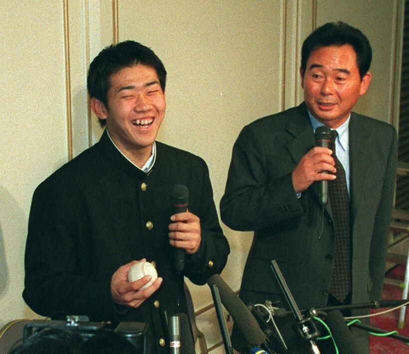 西武との入団交渉の後、東尾修監督（右）とともに記者会見した横浜高校の松坂大輔。東尾監督が２００勝を挙げた時のボールを持ち、笑顔を見せる＝１９９８年１２月　（ｃ）朝日新聞社