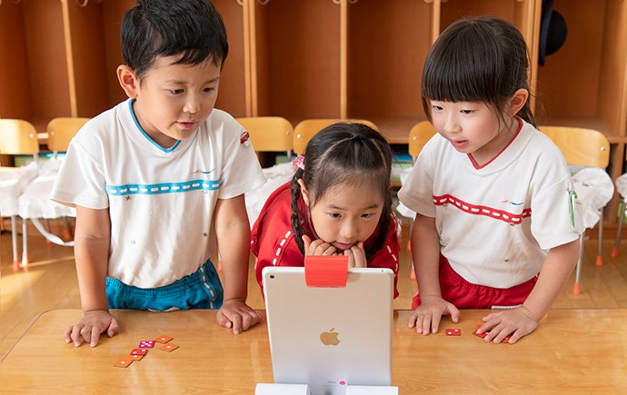 3人1組で「ナンバース」に取り組む。画面に出てくる数字になるように、サイコロの目のゲームピースをタブレットの前に並べる
