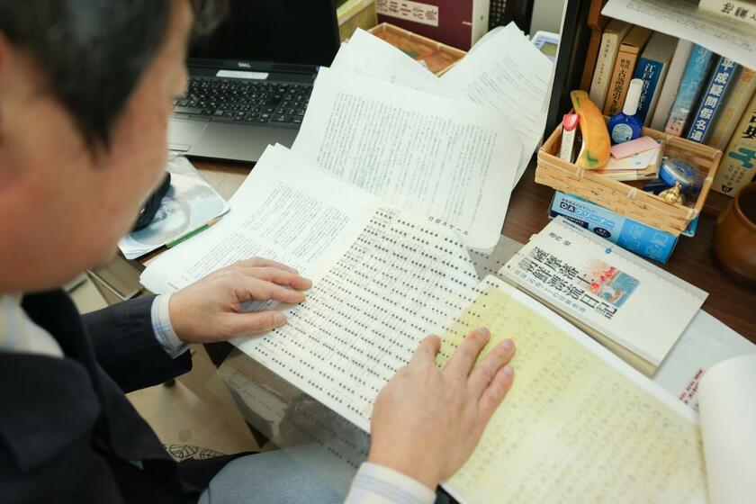 新潮社校閲部の高崎祐一さんのデスクには広辞苑のほか、様々な資料が並ぶ。ゲラを読む際は、体裁のズレなども確認する（photo　張溢文）