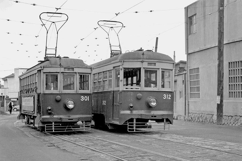 四輪単車の活躍は1964年で終止符が打たれた。北方線の終点北方停留所ですれ違う創業時からの古豪301と和歌山から転入した312。(撮影/加地一雄:1964年11月30日)