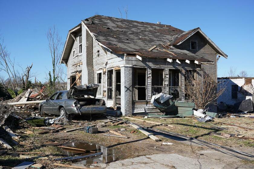 メイフィールドを襲った竜巻で、大きく損壊した住宅と乗用車／12月12日