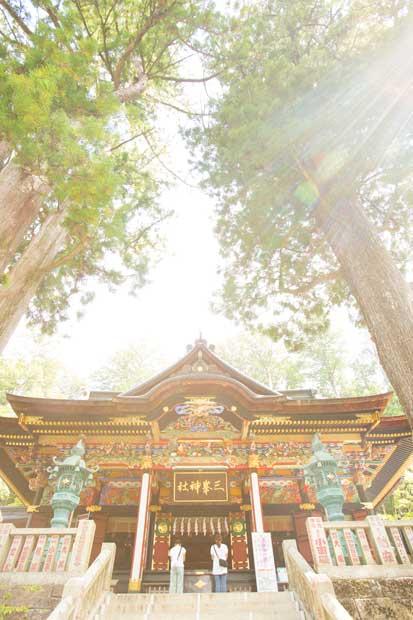 三つ鳥居をくぐり、随身門を抜けた先にあらわれる、三峯神社の色鮮やかな拝殿。拝殿脇には樹齢８００年の神木、重忠杉がある（撮影／写真部・小原雄輝）