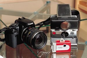 左が事務所のマネージャーからクリスマスにプレゼントされたれたキヤノンEOSKiss Digital X。ポラロイドSX-70といつも持ち歩いているVISTA QUEST VQ1005は、トイカメラが好きなので自分で購入したという。若い女の子らしくインテリアやファッションとしても楽しんでいる