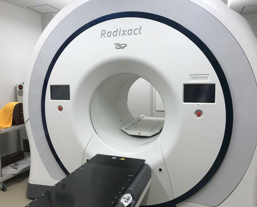 放射線治療装置の「トモセラピー」。筒状の部分が患者の周りを回転しながらあらゆる角度で細いビームを照射する（撮影／白石圭）