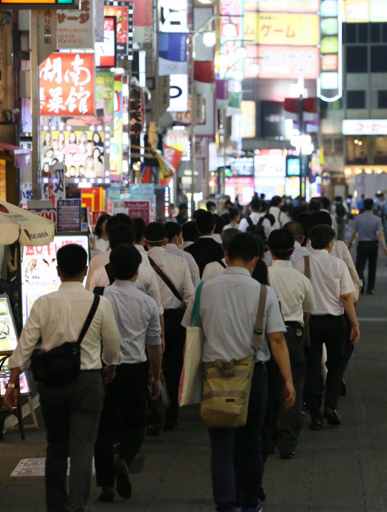 歌舞伎町の立ち入り先に向かう警視庁の捜査員ら＝２０２０年７月２４日夜（C）朝日新聞社
