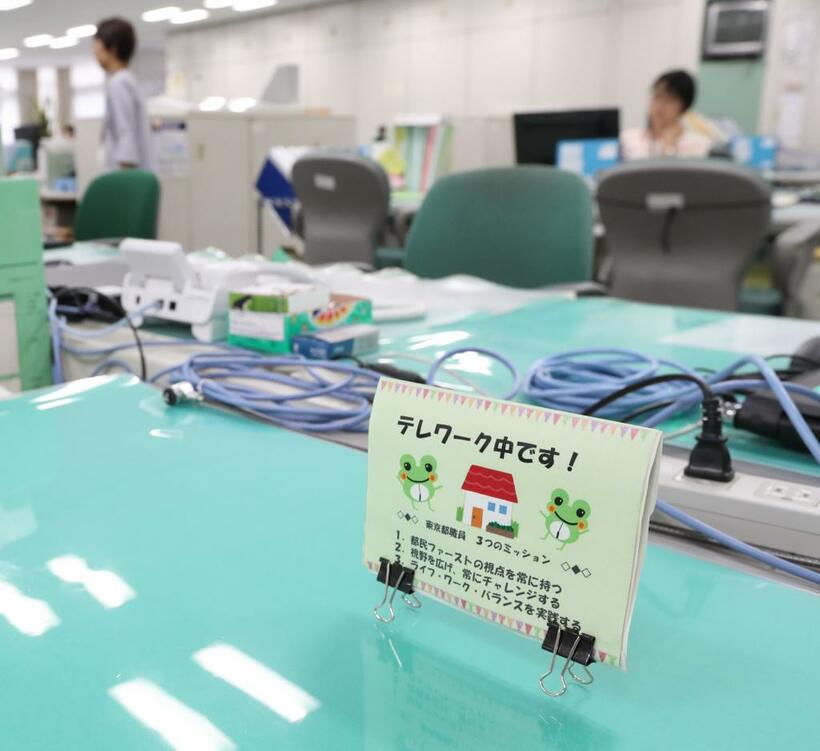 昨年７月、東京都庁。テレワークで不在の職員の机に「テレワーク中」の表示があった　（ｃ）朝日新聞社