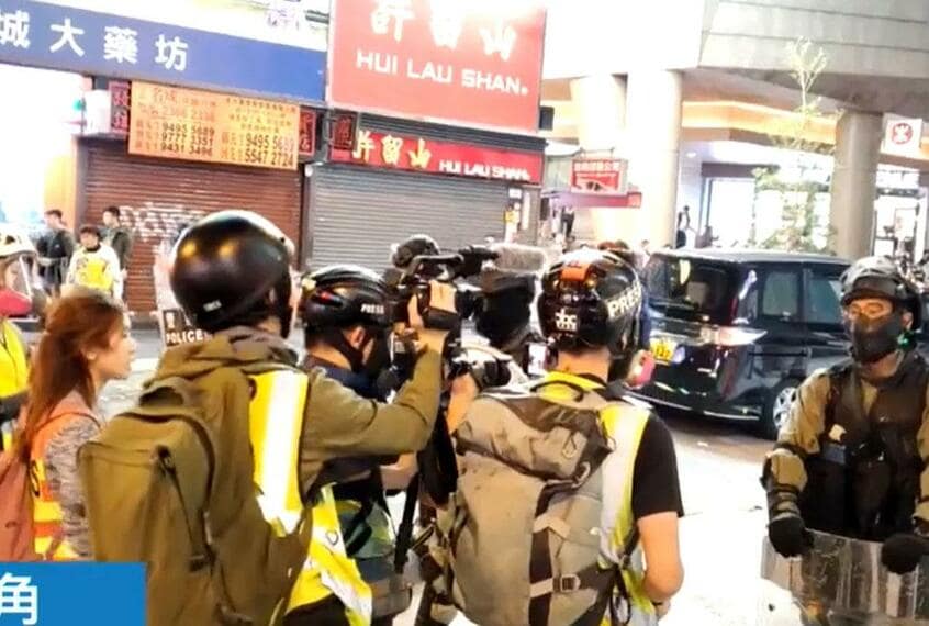 12月15日、抗議行動中の市民に武装警官が催涙弾を撃ち込んだ模様を配信する「蘋果日報」の画面。取材中のメロディ記者(左端)が映り込んでいる(写真:蘋果日報提供)
