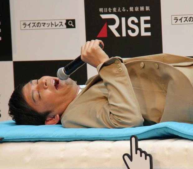 寝具ブランド「ＲＩＳＥ（ライズ）」のマットレスの新商品を体験する、お笑いコンビ「ますだおかだ」の岡田圭右（撮影／大塚淳史）