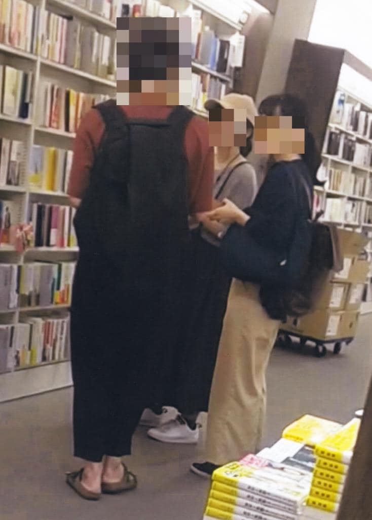 書店で声かけをして勧誘しようとしているアレフの信者（右の２人）。「宗教色を感じさせないＳＮＳや書店などで一般の人との接点を持つ」（公安調査庁）（写真：公安調査庁提供）