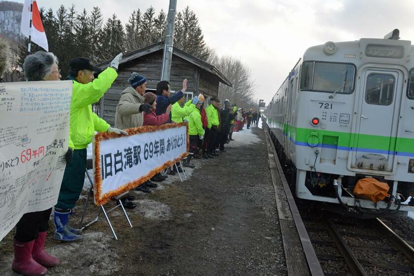 2016年03月25日の白滝駅営業最終日、「６９年間ありがとう」の横断幕を掲げて列車を見送る地元住民。白滝駅は廃駅後、信号場となった　(c)朝日新聞社