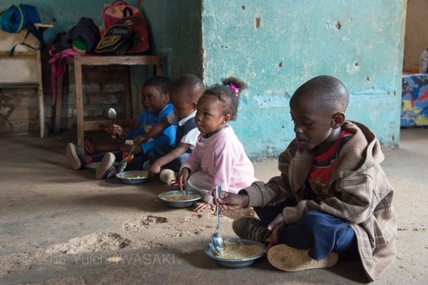 椅子と机はほとんど備えられておらず、床に車座になって給食を食べていた。給食を残す子はいない（チロモニ・マラウイ　2016年／Chilomoni,Malawi 2016）