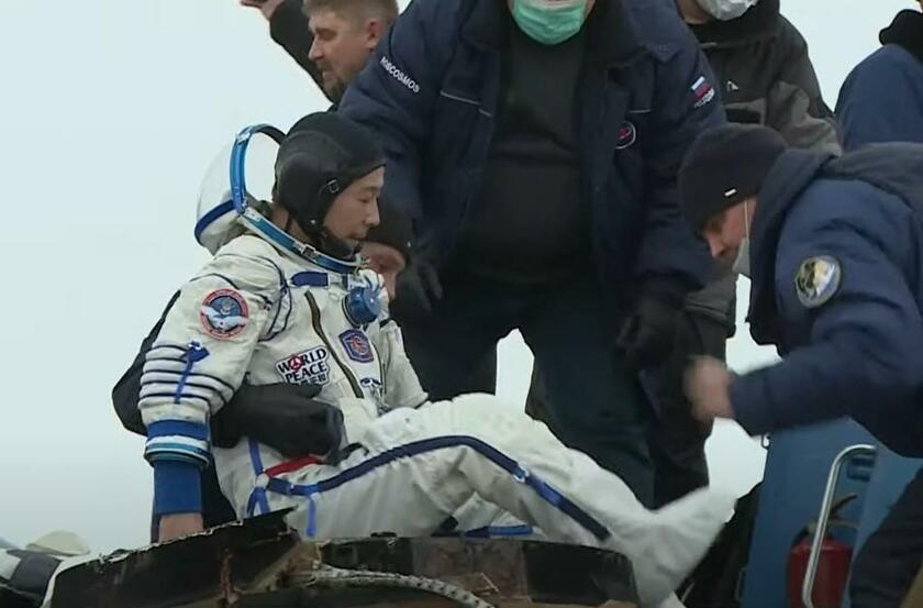 着陸直後のソユーズから担ぎ出される前澤友作さん