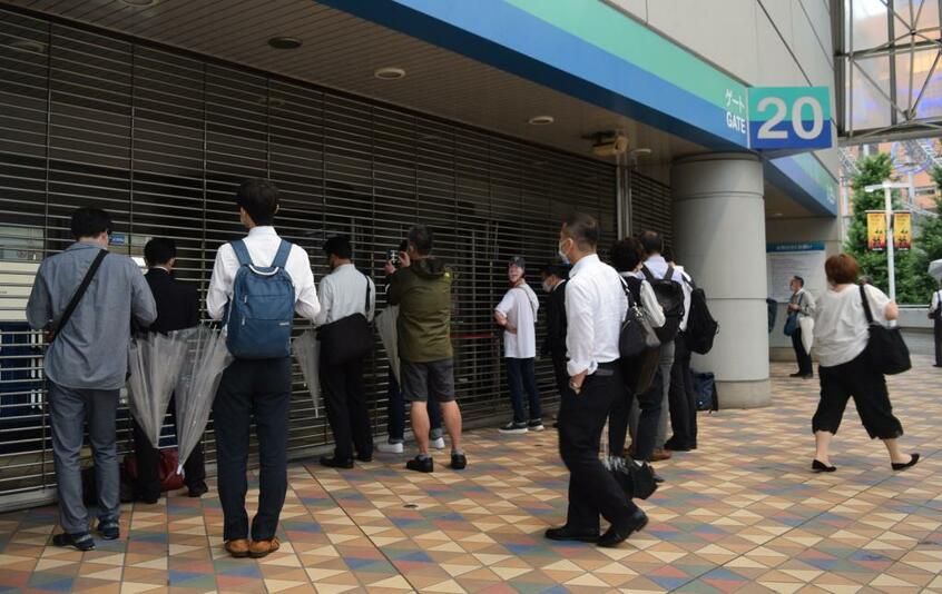閉じられた入場口からドーム内をのぞきこむファンたち(c)朝日新聞社