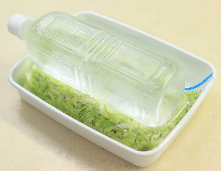 袋の空気を抜き、水の入ったペットボトルなどを重し代わりにして発酵させる。(撮影/写真映像部・松永卓也)