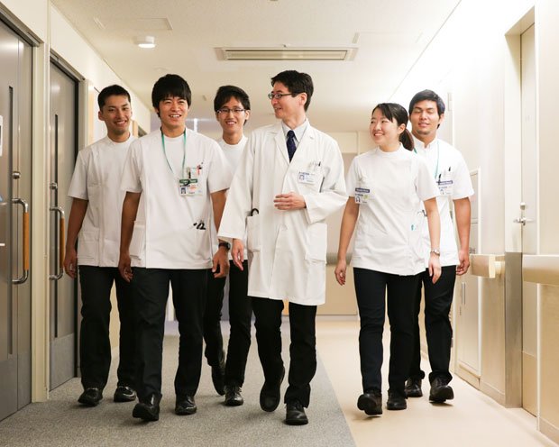 病室に向かう川浪大治講師（左から４人目）、内山敬太さん（左から２人目）と４年生。チームの一員となり、診療に参加する（撮影／岡田晃奈）