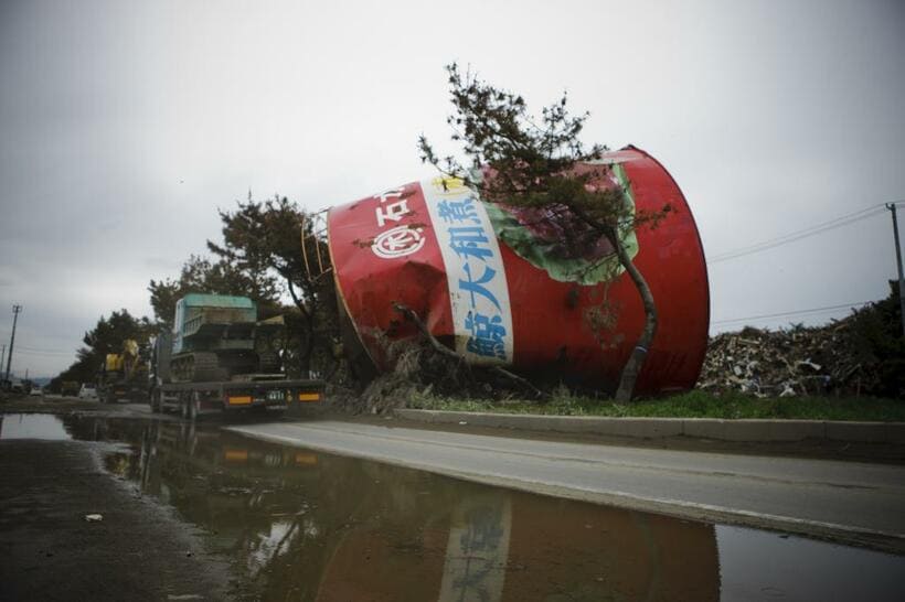 東日本大震災の津波で横倒しになった巨大缶詰。中央分離帯上に残されていたが、12年６月に撤去された／木の屋石巻水産提供