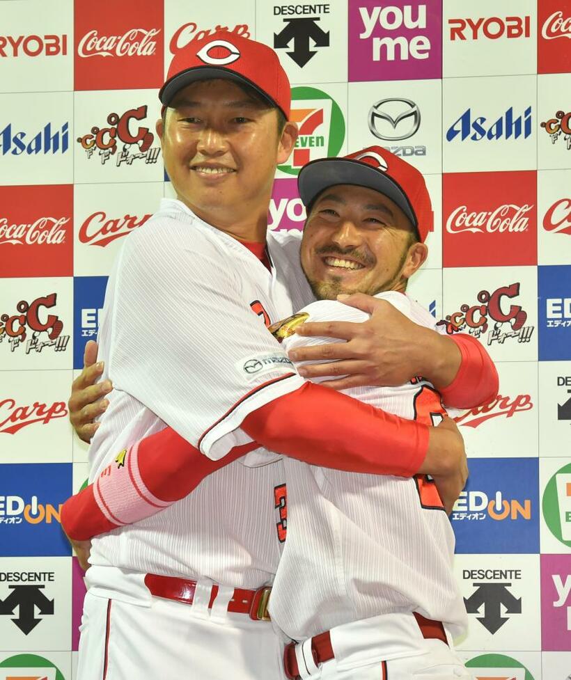笑顔で抱き合う広島の新井（左）と菊池　（ｃ）朝日新聞社