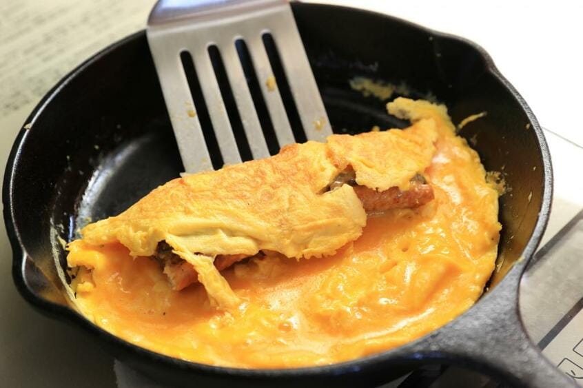 半熟になったら火を止め、うなぎの蒲焼きを中央に置いて奥から手前に巻く。(撮影/写真映像部・松永卓也)
