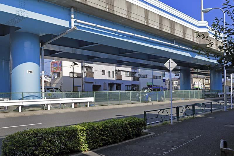 定点観測のポイントとなった緑色の日除けがある「宇田川薬局」の建物を背景に入れ、70年前の今井橋風景をイメージして撮影。画面上空の高架橋は新大橋通り。（撮影／諸河久：2020年10月2日）