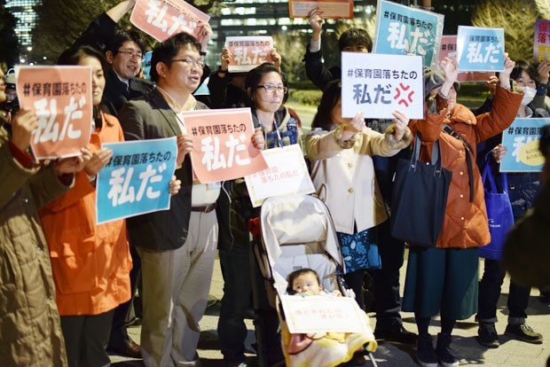 東京・国会議事堂前で、「保育園落ちたの私だ」と書かれた紙を持ち抗議する人たち。男児の上には「落とされたのオレだ！」の文字も　（c）朝日新聞社