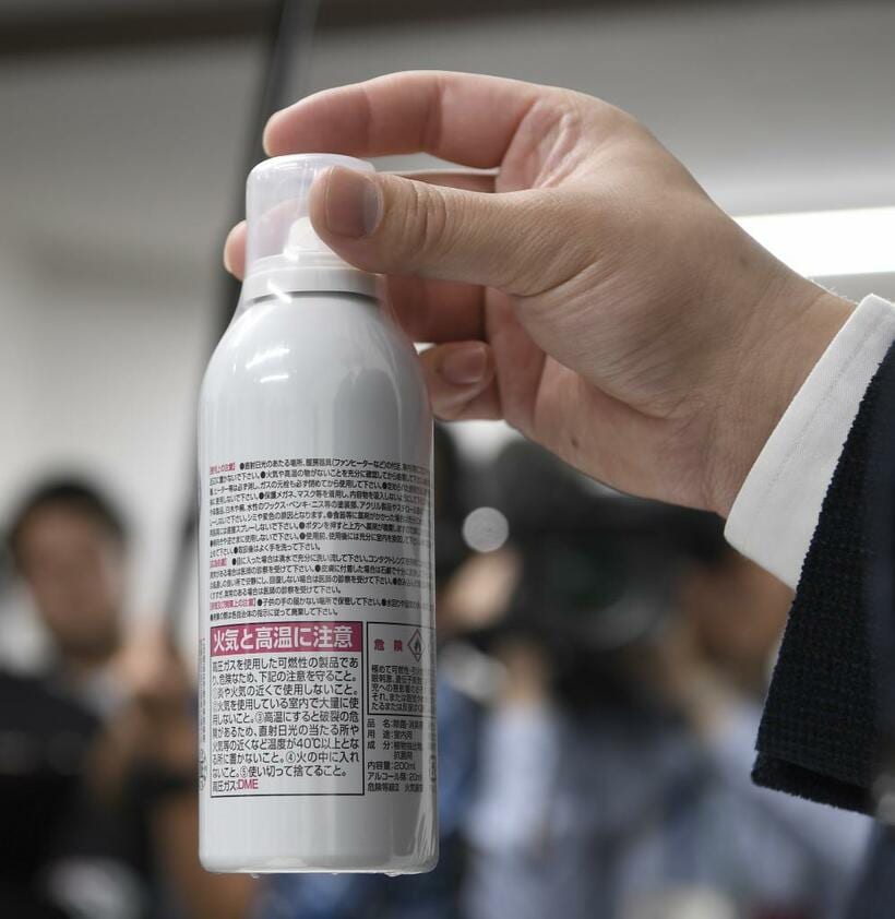 謝罪会見で社長が手にしていたスプレー缶には「火気と高温に注意」という表示があった　（ｃ）朝日新聞社
