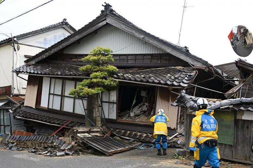 石川県珠洲市で倒壊した家屋を調べる警察官＝2023年5月6日